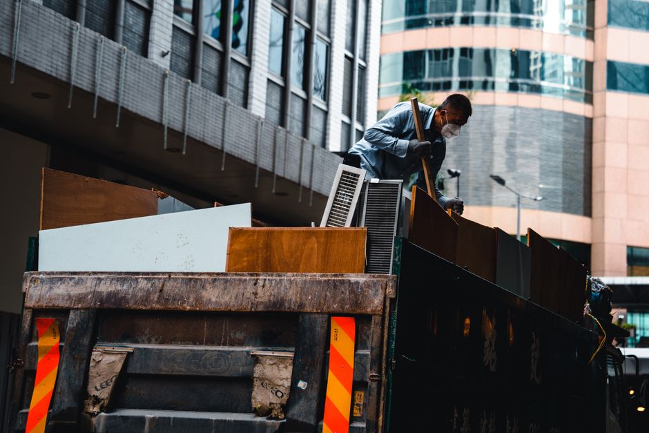 Worker loading debris into a dump trailer